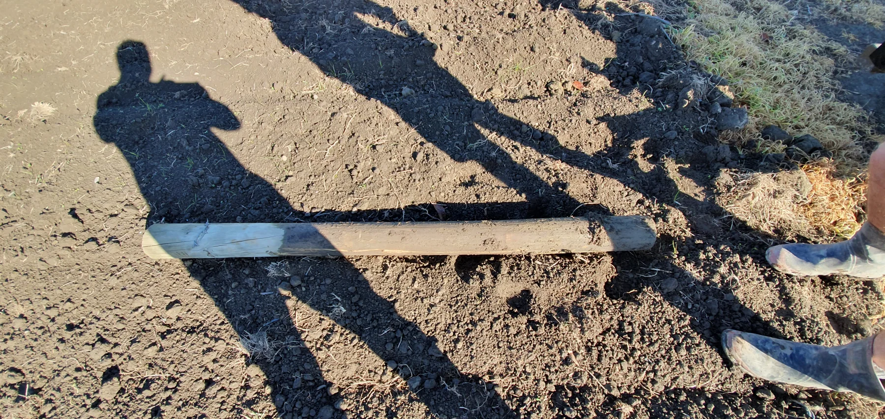Field post lying on ground during post lifter reference work