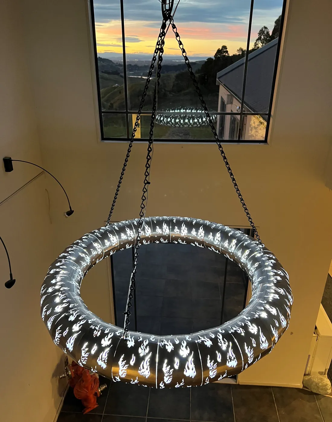 Large laser-cut ring light glowing in an atrium setting.