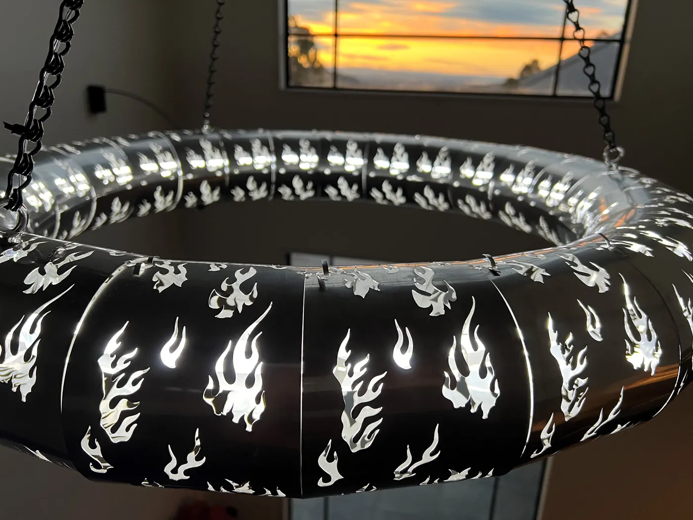 Close detail of laser-cut flame pattern lighting with warm backlight.